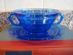 a blue glass bowl sitting on top of a book