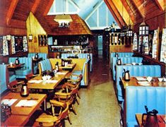 the inside of a restaurant with wooden tables and blue booth booths, wood ceilinging