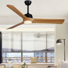 a living room with a ceiling fan in the middle of it's wooden blades