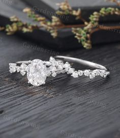 an oval cut diamond ring on top of a wooden table