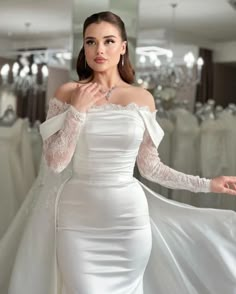 a woman in a white dress posing for the camera with her hands on her hips