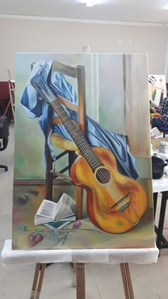 an easel with a painting of a guitar on it