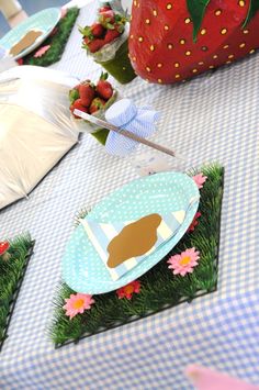 a table with plates and strawberries on it