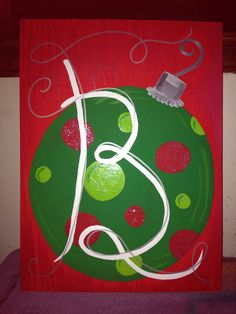 a green and red christmas ornament with white swirls on it's side