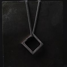 Square Pendant Necklace The square can represent basics, structure, and balance. The square will symbolize community, integrity, direction, and being practical and elemental. Wear this necklace as an amulet for order and stability in your life. This square pendant is a rustic piece of design made of 100% sterling silver. Size and Fit: The pendant's size: 16 mm x 17 mm You can choose to purchase only the pendant or add an oxidized sterling silver chain to it. The Details This necklace is made in Symbolic Square Pendant Necklace With Engraving, Sterling Silver Amulet Necklace With Square Pendant, Silver Symbolic Necklace With Square Pendant, Symbolic Silver Necklace With Square Pendant, Modern Necklace With Box Chain And Square Pendant, Square Box Chain Necklace For Gift, Spiritual Sterling Silver Square Pendant Necklace, Square Pendant Jewelry With Box Chain, Minimalist Silver Square Necklace