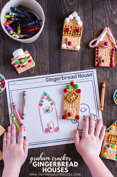 a person making gingerbread house cookies with crayons and colored pencils on the table