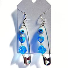 a pair of earrings with blue glass beads and white pearls hanging from the end of each ear