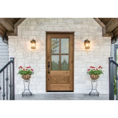 a wooden door with two planters on the front porch