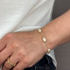 Indulge in the timeless beauty and sophistication of our 18k Gold Filled Spaced Baroque Pearl Bracelet. The perfect blend of elegance and delicacy, this classic piece exudes a luxurious charm that will elevate any outfit. Add a touch of opulence to your wardrobe and captivate with every turn of your wrist. Metal: 18k Gold Filled Width: 10mm Simulated Baroque Pearl Beads Size: 6.5 + 1 inch adjustment. Hypoallergenic Water-resistant Handcrafted in Brazil Elegant Pearl Chain Bracelet For Formal Occasions, Elegant Adjustable Pearl Chain Bracelet, Elegant Oyster Bracelet As Gift, Elegant White Chain Bracelet With Pearl Charm, Elegant Gold Bangle Bracelet With Elegant Design, Elegant Round Chain Bracelet, Elegant Rose Gold Chain Bracelet For Everyday, Elegant Yellow Gold Bracelet For Everyday Luxury, Luxury Pearl Chain Bracelet For Formal Occasions