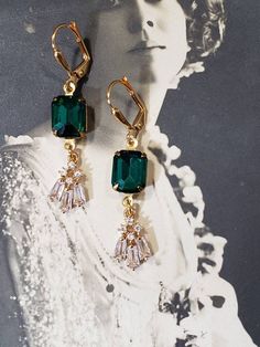 These Art Deco style earrings are inspired by the gorgeous emerald and diamond jewelry worn during the 1920s. Sparkling clear rhinestone pendants dangle from emerald green rhinestone connectors. The earrings measure 1 3/4 inches long and hang from gold plated lever back ear wires. These elegant dangles are reminiscent of the geometric shaped rhinestone jewelry worn during the Jazz Age. Perfect for a Great Gatsby themed wedding or party. ABOUT THIS COLLECTION The sophisticated style of the Roarin 1920 Jewelry, Gala Earrings, Art Deco Jewelry Earrings, Flapper Jewelry, Art Deco Jewelry 1920s, Emerald Green Art, 1920s Jewelry, Green Art Deco, Great Gatsby Wedding