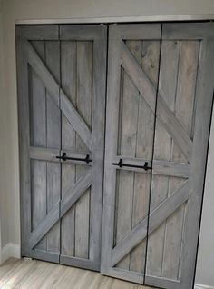 an open barn door in a room with hard wood flooring and white painted walls