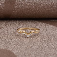 a diamond ring sitting on top of a piece of cloth next to a brown pillow