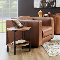 a living room with two brown couches and a table in front of the window