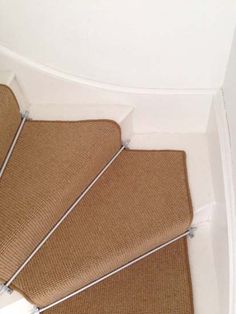 a cat sitting on top of a carpeted stair case