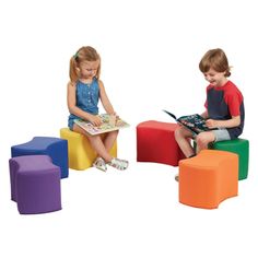 two young children sitting on colorful stools reading books in front of eachother