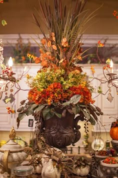 a vase filled with lots of different types of flowers next to a chandelier