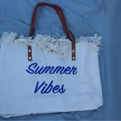 New With Tags Great Tote Size White Bag With Summer Vibes Embroidered In Navy Blue Material: Canvas Snap Closure 18.9 In (L) X 4.33 In (W) X 13.39 In (H) White Summer Canvas Shoulder Bag, Trendy White Beach Bag With Adjustable Strap, Trendy White Bags For Beach Season, White Canvas Bag For Vacation, Trendy White Canvas Bag For Summer, White Crochet Shoulder Bag For Beach Season, Blue Summer Bags For Weekend, Blue Summer Beach Bag For The Weekend, Blue Summer Weekend Bag