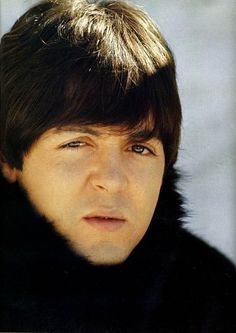 a close up of a person wearing a fur coat and looking at the camera with a serious look on his face