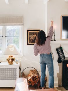 a woman standing next to a fire place in a living room