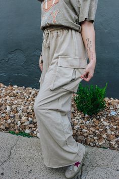 Get ready to slay the day with these Effortless Behavior Khaki Pants! With a stylish drawstring and wide leg cargo design, these pants will keep you looking on-trend while also being ultra-comfortable. The mineral wash adds a unique touch to your wardrobe. Perfect for any casual or dressy occasion, these pants are a must-have! *lighting may differ the color Spring Utility Wide Leg Pants With Pockets, Utility Wide Leg High-waisted Pants With Side Pockets, Utility Parachute Pants For Loungewear, Utility Wide Leg Pants With Cargo Pockets, Wide Leg Sweatpants With Hip Pockets For Spring, Summer Wide Leg Cargo Jeans With Multiple Pockets, Wide Leg Cargo Jeans With Multiple Pockets For Summer, Wide Leg Summer Cargo Jeans, Summer High Waist Wide Leg Pants With Cargo Pockets