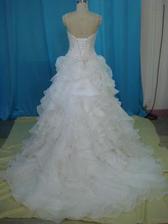 a wedding dress on display in front of a blue curtain