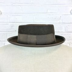 "Size 6 7/8 Vintage 1950s 1960s Adam Hats Carbon Brown Porkpie Fedora Hat For your consideration we have a vintage fedora from the '50s/'60s. Made by Adam Hats from a \"carbon brown\" fur felt, this \"Rugby\" model features a telescopic crown, brown grosgrain band and edge, leather sweatband, and rayon lining. There are a few spots on the hat band and a few stitches have come out of the leather sweatband. This is still a great hat and wonderful for anyone into slick bop midcentury style. Measure Retro Winter Fedora With Curved Brim, Retro Curved Brim Felt Hat For Winter, Retro Adjustable Felt Hat With Flat Brim, Retro Winter Hat With Flat Brim, Retro Flat Brim Winter Hat, Retro Winter Fedora With Flat Brim, Retro Flat Brim Fedora For Winter, Vintage Fedora For Kentucky Derby With Flat Bill, Retro Curved Brim Top Hat For Winter