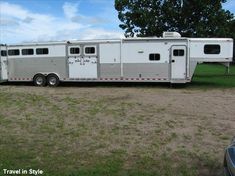 a horse trailer is parked in the grass