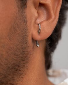 a man wearing a pair of diamond earrings