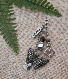 a close up of a key chain on a cloth with a fern leaf in the background