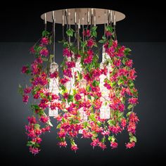 a chandelier with pink flowers hanging from it's sides and green leaves