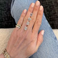 a woman's hand with three different rings on her left and two diamonds on the right