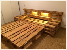 a bed made out of wooden pallets with lights