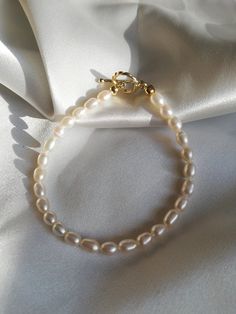 This Genuine Freshwater Pearl Bracelet/Modern Pearl Jewelry/Seed White Pearl Bracelet/Tiny Pearl Bracelet/Golden Toggle Pearl Bracelet is made with genuine seed freshwater pearl beads and a golden toggle. The pearl is rice-shaped, which creates a slim and modern feeling. The toggle adds more delicacy to it. This bracelet can be worn alone or be stacked with other golden bracelets to create a casual and modern feeling. It is a perfect gift for yourself or your loved ones. Domestic shipping is inc Elegant Charm Bracelet With Toggle Clasp, Adjustable Single Strand Pearl Bracelet As Gift, Adjustable Chain Bracelet With Toggle Clasp As Gift, Classic Bracelets With Toggle Clasp As Gift, Classic Bracelets With Lobster Clasp As Gift, Classic Bracelets With Lobster Clasp For Gifts, Classic Handmade Pearl Bracelet For Everyday, Classic Beaded Bracelets With Lobster Clasp As Gift, Elegant Charm Bracelet With Toggle Clasp As Gift