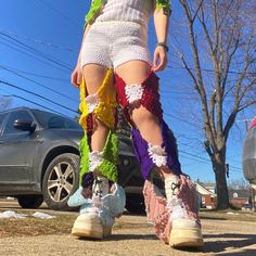 a woman in colorful crochet boots walking down the street