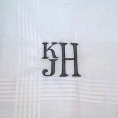 the monogrammed letter h is displayed on a white sheet