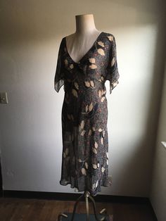 "1970s handmade gauze dress no tags see through leaf and squiggly patern pullover good vintage condition, light wear tiny seed size hole to left sleeve measures, lying flat, neck to sleeve-10\" chest-8\" waist-14\" length-44\"" Bohemian V-neck Dress With Vintage Print, Vintage Boho Print V-neck Dress, Vintage Print V-neck Summer Dresses, Summer Vintage Print V-neck Dress, Summer V-neck Dress With Vintage Print, Summer V-neck Vintage Print Dresses, Hippie Fitted Short Sleeve Dress, Vintage V-neck Boho Print Dress, Vintage Patterned Short Sleeve Dresses