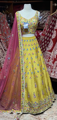 Saffron yellow lehenga elaborate work done all over the lehenga with multicolor resham detailing in floral design and highlighted with flux mirror and zari embroidery. Accomplished with similarly embroidered blouse and Look outstanding by styling a contrasting pink cut net dupatta. A saffron yellow that is not only dreamy but whimsical as well. Fabric : Silk Size: 38 Ready to Ship! Bollywood Style Resham Embroidered Anarkali For Festivals, Bollywood Style Anarkali Set With Resham Embroidery For Festivals, Eid Anarkali Lehenga In Chanderi, Navratri Tissue Silk Sharara With Resham Embroidery, Festive Kundan Anarkali Set With Dori Work, Pista Green Raw Silk Sharara For Festivals, Festive Pista Green Raw Silk Sharara, Anarkali Semi-stitched Choli With Zari Work, Festival Sharara With Resham Embroidery In Chinon