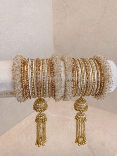 Antique gold, champagne crystal middle jhumka tassel bangle and clear crystal beaded end bangles mixed with cream shades. Sold as a set for both arms only. Ready to Ship! Bangle Box, Indian Accessories, Gold Bangle Set, Bridal Choker, Bridal Necklace Set, The Bangles, Bracelets Design, Gold Champagne, Bridal Bangles