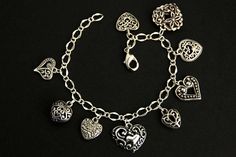 A collection of silver filigree-style heart charms have been dispersed around a shimmering silver plated bracelet chain in this handmade charm bracelet. This heart charm bracelet is then completed with a lobster clasp and a 1/2 inch of chain at the end for adjustable sizing. Charms in this bracelet include nine assorted heart charms in various decorative filigree designs. ● Sizing ● To determine your bracelet size, do a snug measurement of your wrist's circumference, then add 1/2 an inch. 6 to 6 Silver Heart-shaped Bracelet With Charms, Vintage Heart-shaped Bracelets With Charm, Elegant Heart-shaped Stainless Steel Charm Bracelet, Heart-shaped Metal Charm Bracelet With Adjustable Chain, Elegant Sterling Silver Heart-shaped Charm Bracelet, Handmade Charm Bracelets, Silver Plated Bracelet, Filigree Design, Handmade Charms