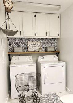 a washer and dryer in a laundry room with white cabinets, black and white tile