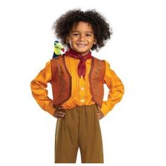 a young boy wearing an orange shirt and brown pants with a bird on his shoulder