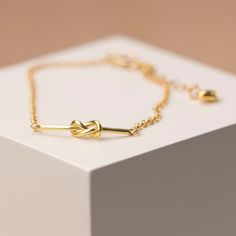 A beautiful gold filled trace chain winds into a knot that is the perfect symbol of a marriage ceremony. It will make a gorgeous accessory to the bride's wedding dress and is such an appropriate gift for a bridegroom to offer his bride on her wedding day or for her bridesmaids helping make the day special, what a lovey bridesmaid gift. The bracelet also features a 12mm gold plated over sterling silver pendant attached to the lobster clasp. We can engrave with up to 25 characters. Perhaps an initial, name, message for the bridesmaids or the wedding date for the bride? This gorgeous gift comes in a grey gift box. - Yellow gold filled - 17cm long with 20mm extender chain - Lobster clasp - Heart detail - Eco-friendly gift box Wedding Knot, Lovers Knot, Engraved Pendant, Bracelet Box, Gold Armband, Initial Name, The Wedding Date, Knot Bracelet, Brides Wedding Dress