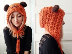 a woman wearing an orange knitted hat with ears