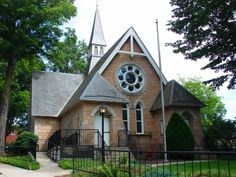 an old church with a clock on it's face and stained glass window in the front