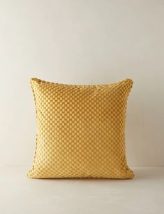 a yellow pillow sitting on top of a white table