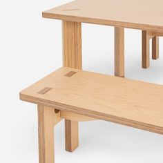 two wooden benches sitting next to each other on top of a white surface with no one around them