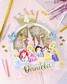 a pink birthday card with princesses on it and the name danielle surrounded by confetti sticks