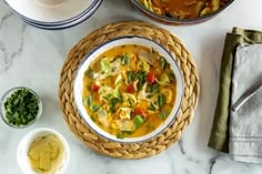 a table topped with bowls filled with soup and other food items on top of it