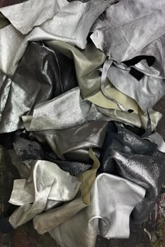 an assortment of silver and black cloths on the ground