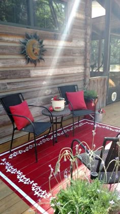 an outdoor patio with chairs, table and potted plants on the rug in front of it